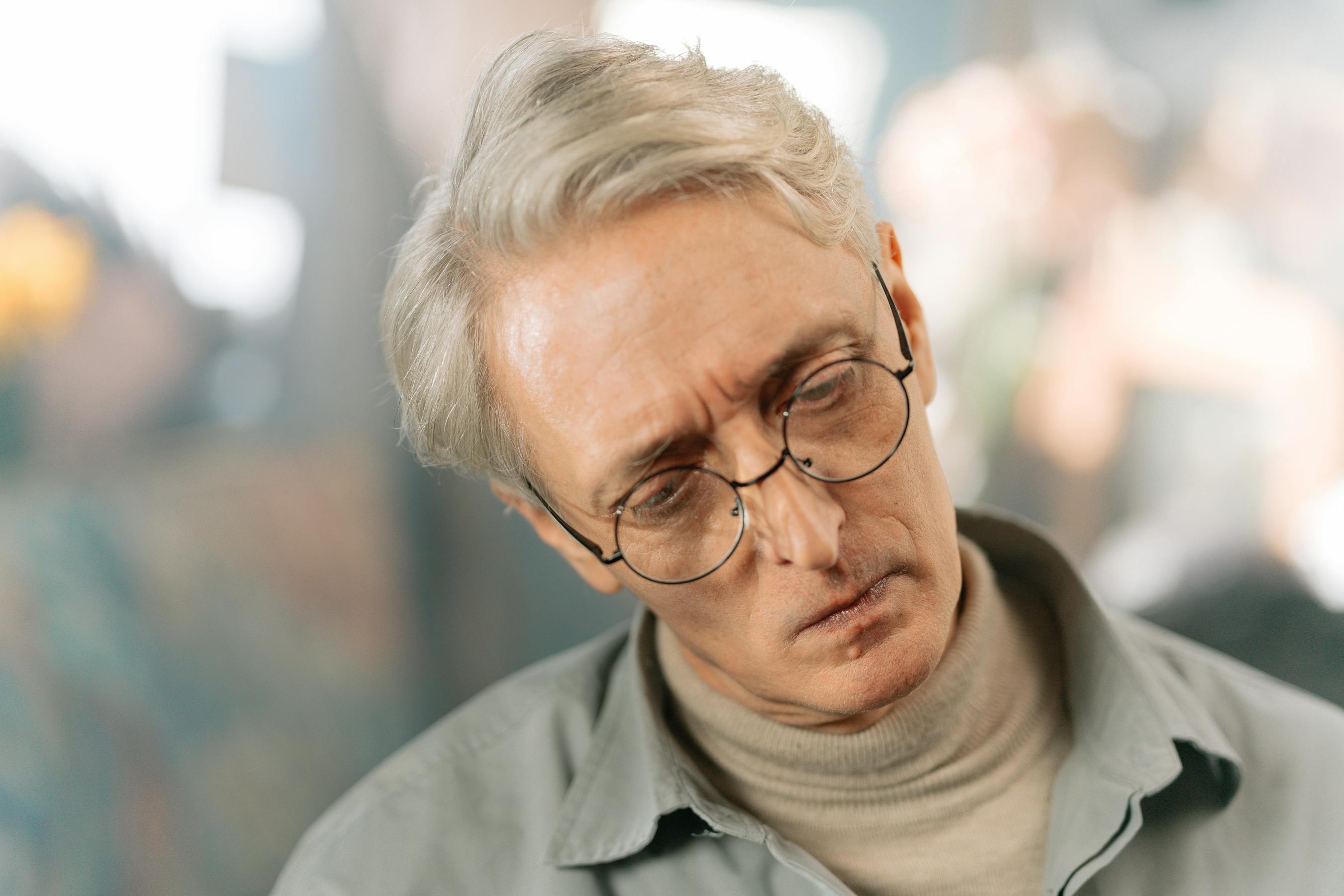 Homme senior pensif, illustrant les signes d'une perte auditive progressive à ne pas ignorer